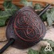 Barrette artisanale en cuir ovale ornée d'une Triquetra celtique marron entourée de volutes médiévales.