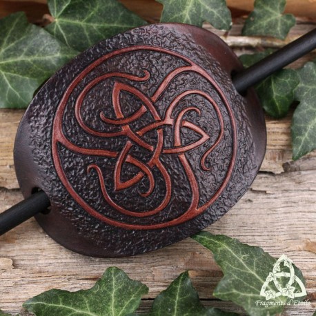 Barrette artisanale en cuir ovale ornée d'une Triquetra celtique marron entourée de volutes médiévales.