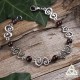 Bracelet médiéval et féerique Faerell orné de Spirales argentées entourées de perles de Grenat rouge foncé.