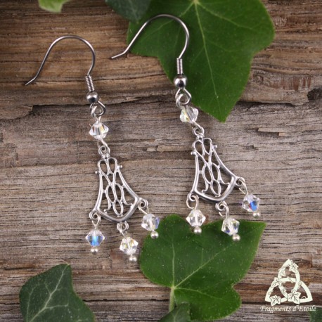 Boucles d'oreilles féeriques aux volutes elfiques argentées et ajourées ornées de perles de cristal blanc.