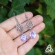 Boucles d'oreilles féeriques aux jolies volutes rondes argentées ornées d'une pierre mauve aux belles facettes violettes.