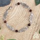 Bracelet médiéval viking orné d'entrelacs celtiques infinis argentés et perles de Grenat rouge foncé.