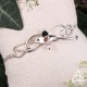 Bracelet artisanal en argent 925, fabriqué en France. Il est orné de volutes elfiques et d'une fleur ornée d'un Grenat.