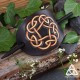 Gros plan sur le motif d’entrelacs repoussé sur barrette ovale en cuir marron et beige
