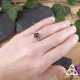 Bague Ceangal portée – Grenat rouge et argent 925 sur main de femme, style médiéval fantasy