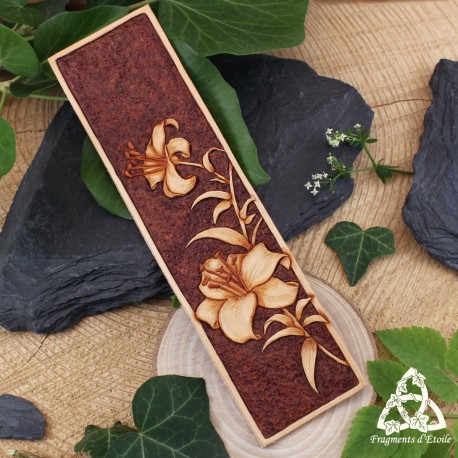 Marque-page artisanal en cuir Lysëa, fleurs de lys en relief, style médiéval fantasy, présenté sur fond végétal