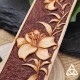 Détail de la fleur de lys repoussée à la main sur cuir, relief et teinture marron clair, motif nature et féerie