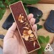Marque-page Lysëa en cuir, style elfique et nature, tenu dans une main pour illustrer la taille réelle