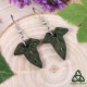 Boucles d’oreilles Iseys – feuilles de lierre en cuir vert foncé, inspiration elfique et nature, sur fond bois