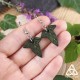 Boucles d’oreilles Iseys en cuir vert foncé – posé sur main de femme en taille réelle, inspiration Seigneur des Anneaux