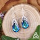 Boucles d'oreilles Larme de Cristal bleu reflets vert - vue principale sur fond bois, style elfique et nature