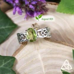 Bague celtique Arkerian en argent 925 rhodié avec péridot vert facetté, vue de face sur bois, style médiéval fantasy