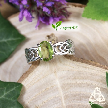 Bague celtique Arkerian en argent 925 rhodié avec péridot vert facetté, vue de face sur bois, style médiéval fantasy