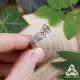 Gros plan de la bague Arkerian tenue entre les doigts, montrant le péridot et les entrelacs celtiques en détail.