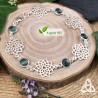 Bracelet Yaell en argent 925 et topaze bleue facettée, fleurs de vie ajourées, vue de côté sur fond bois, mention "argent 925".