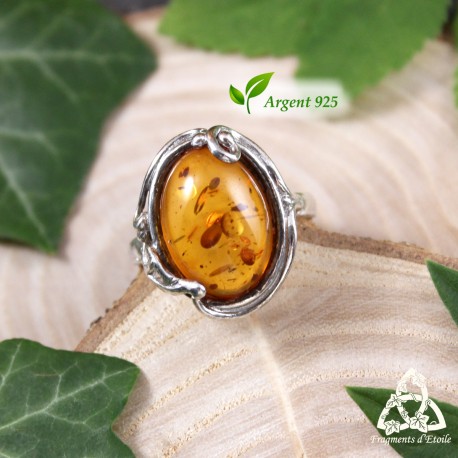 Bague elfique Ellea en argent 925 et Ambre véritable, vue de face sur fond bois et feuilles, style médiéval fantasy