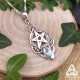 Pendentif Celtic Witch argent 925 avec goutte en Topaze bleue, posé sur fond bois entouré de feuilles naturelles