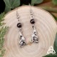 Boucles d’oreilles ornées d’un petit loup argenté et de perles de Grenat rouge foncé, sur fond bois, style médiéval fantasy
