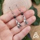 Boucles d’oreilles féeriques avec loup argenté et Grenat naturel rouge foncé, présentées sur une main pour montrer leur taille
